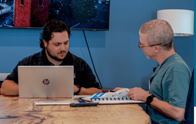 An ASG advisor reviewing an IT plan at a conference table