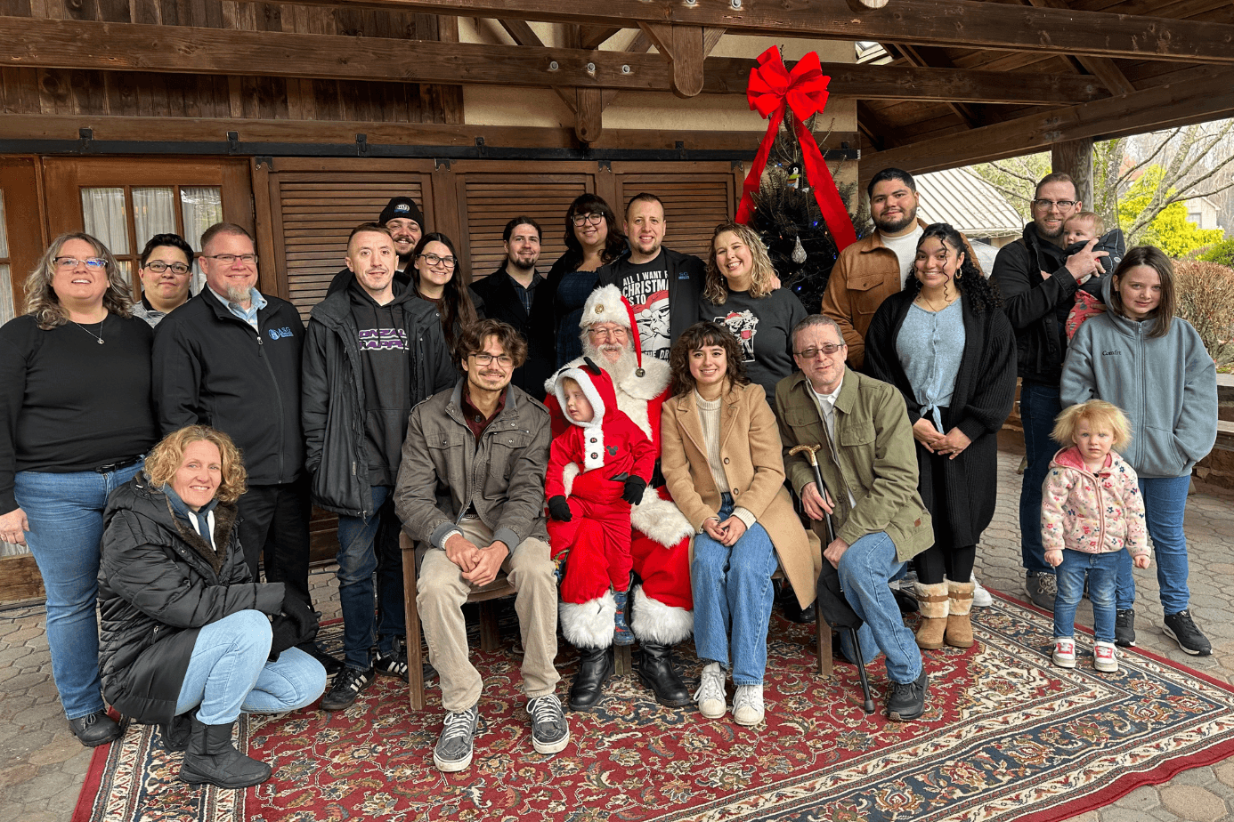 ASG team members and their families with Santa at the company holiday party
