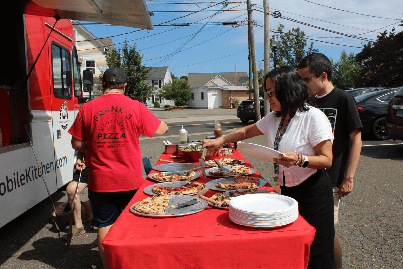 The ASG team enjoying wood-fired pizza from a food truck at a company lunch