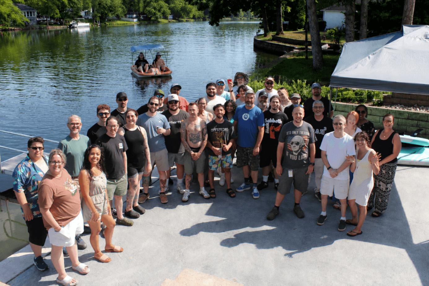The ASG Information Technologies team gathered on the lake dock at the annual Steak & Beer Fest 2026
